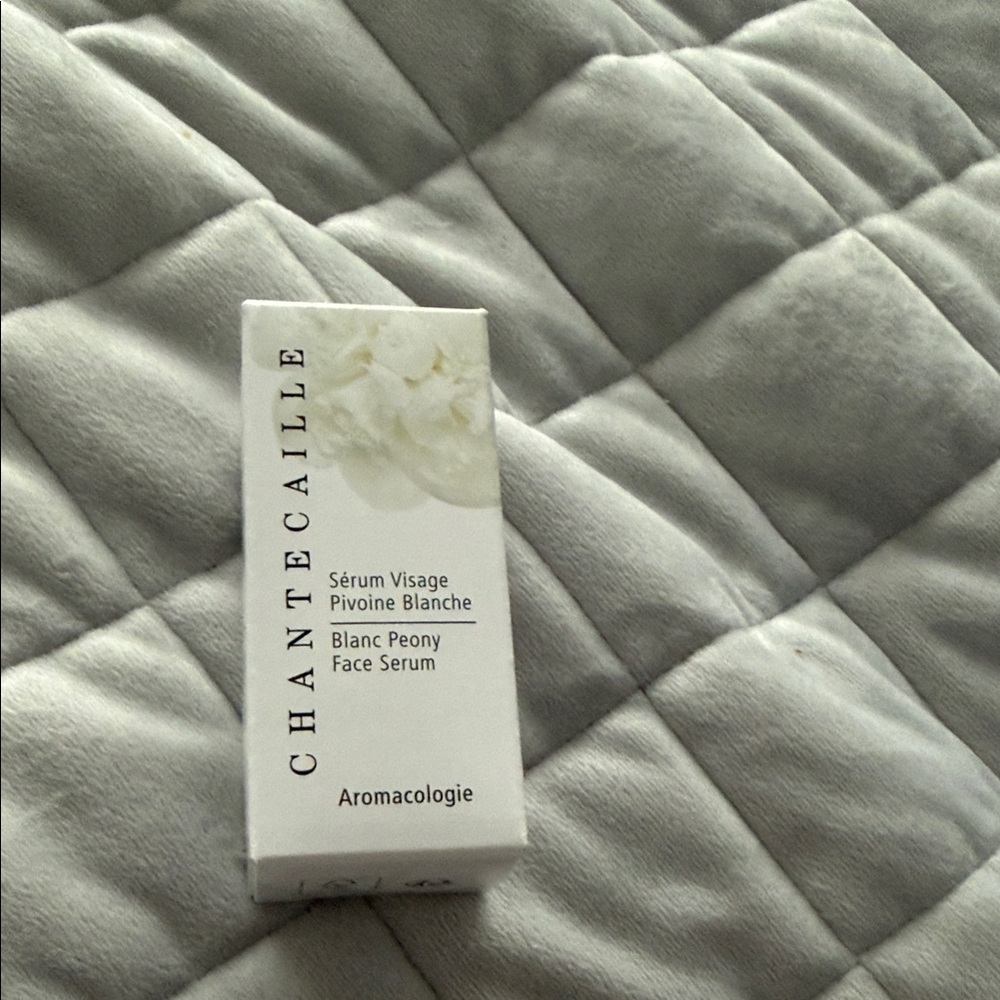 Chantecaille White Face Serum Box on Gray Quilted Bedding
